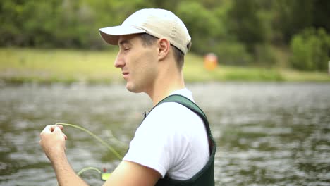 toma en cámara lenta de un pescador caucásico lanzando su anzuelo mientras pesca con mosca-11