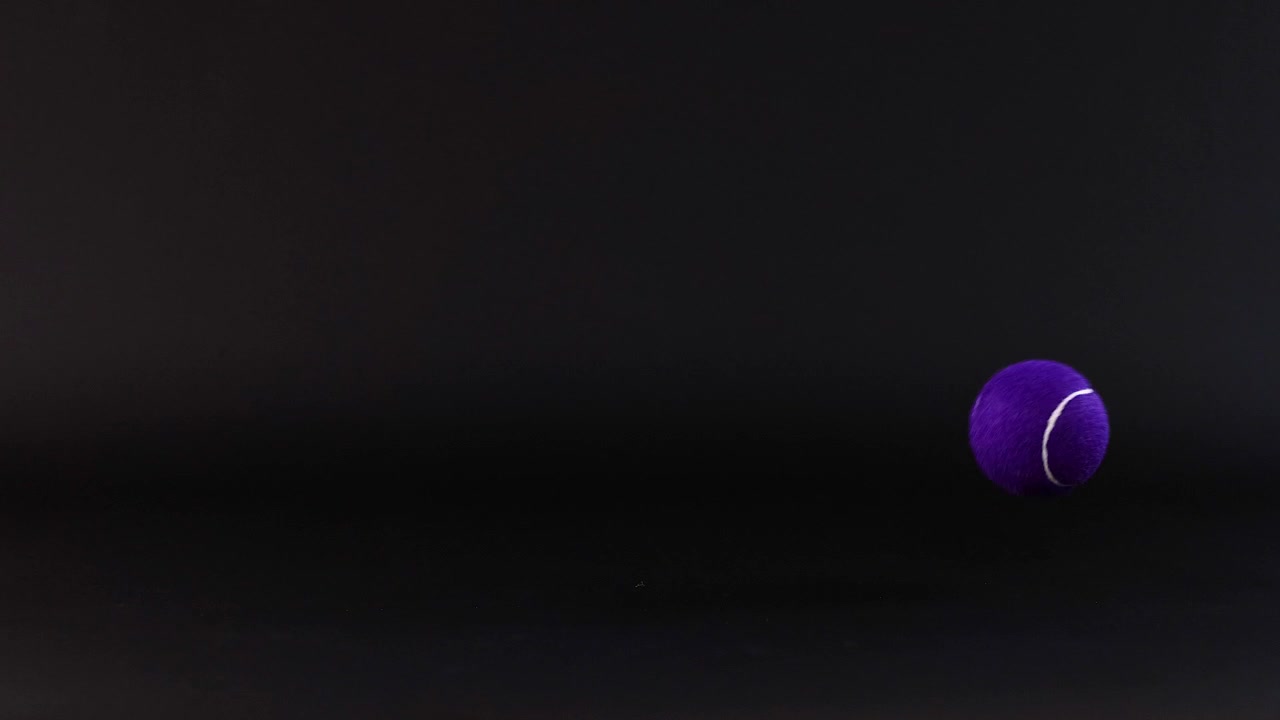 Tennis ball bouncing against a dark background