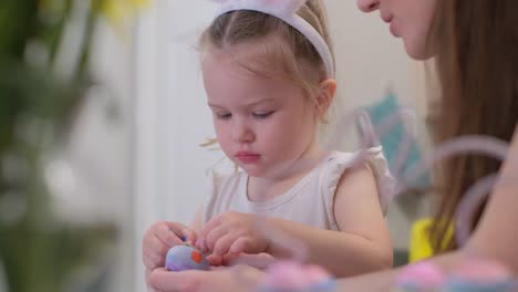 happy easter. mother and child with bunny ears preparing for the holiday. painting eggs