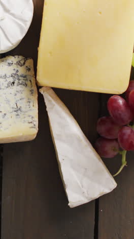 video of diverse cheeses, grapes and wine on wooden surface