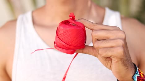 artisan unwinding red raffia for craft