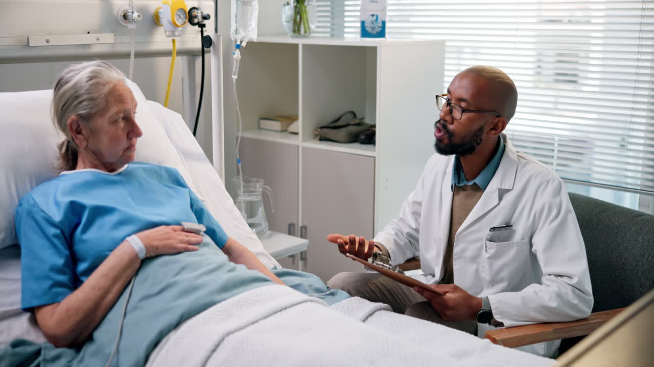 Doctor Consulting with Elderly Patient in Hospital