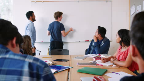 alumno de secundaria masculino escribiendo en la pizarra en la clase de matemáticas