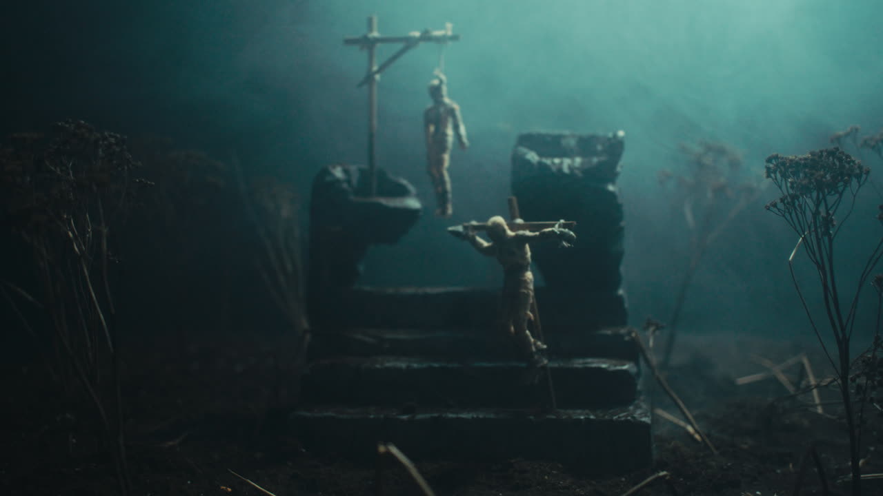 A miniature scene of the mummified dolls hanging on the gallows at night