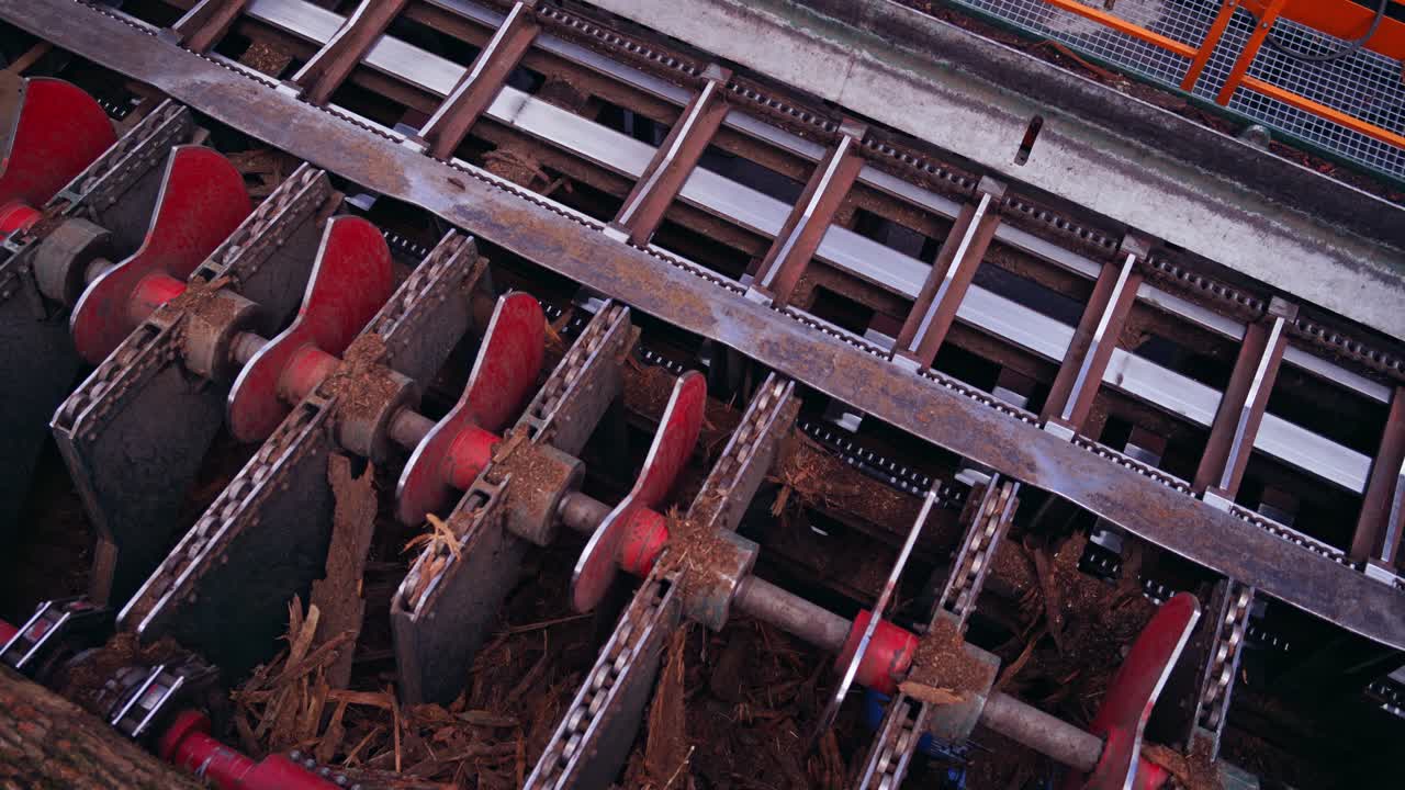 Sawmill. Process of removing bark from logs. Special machinery with conveyor. heavy technic at plant, Timber industry. View from the top.
