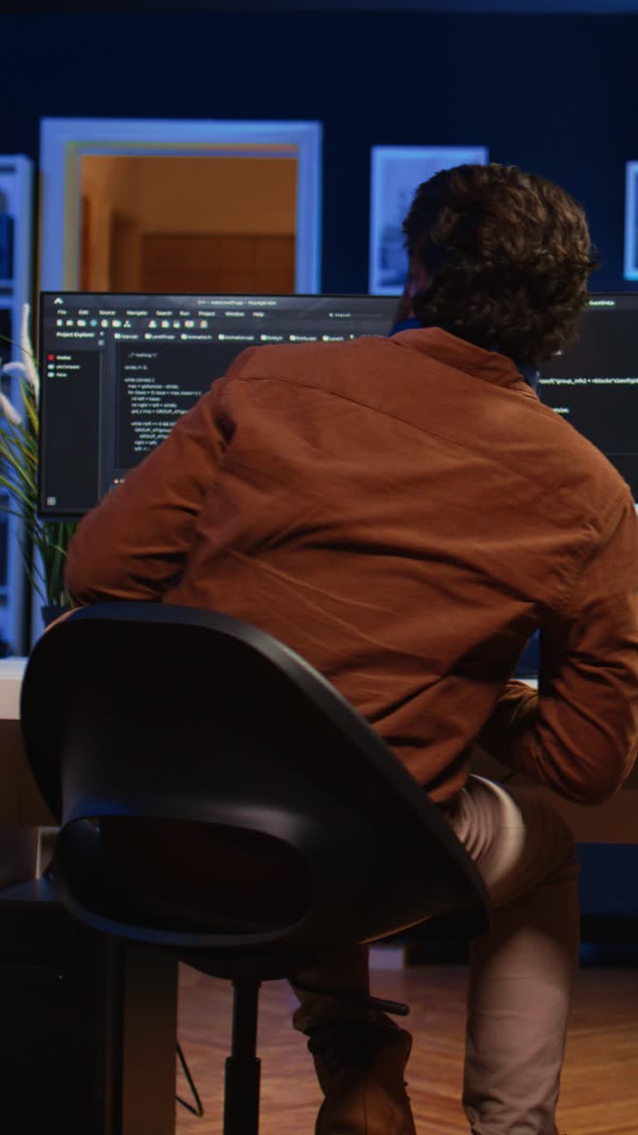 Focused Programmer Working on Tablet and Computer in Dark Office