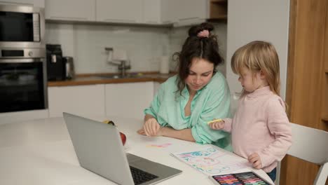 Beautiful-mom-helps-her-young-daughter-with-her-drawing