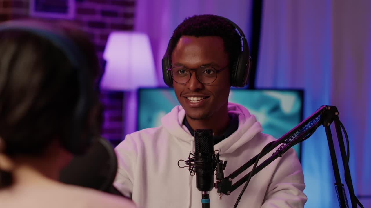 Portrait of smiling african american online radio host listening to interesting conversation with influencer