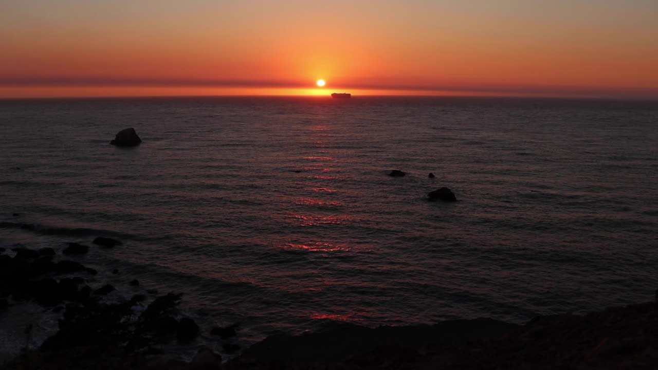 고요한 여름밤에 수평선을 만나는 태양을 건너는 배와 함께 북부 캘리포니아 해안을 따라 아름다운 황금빛 일몰