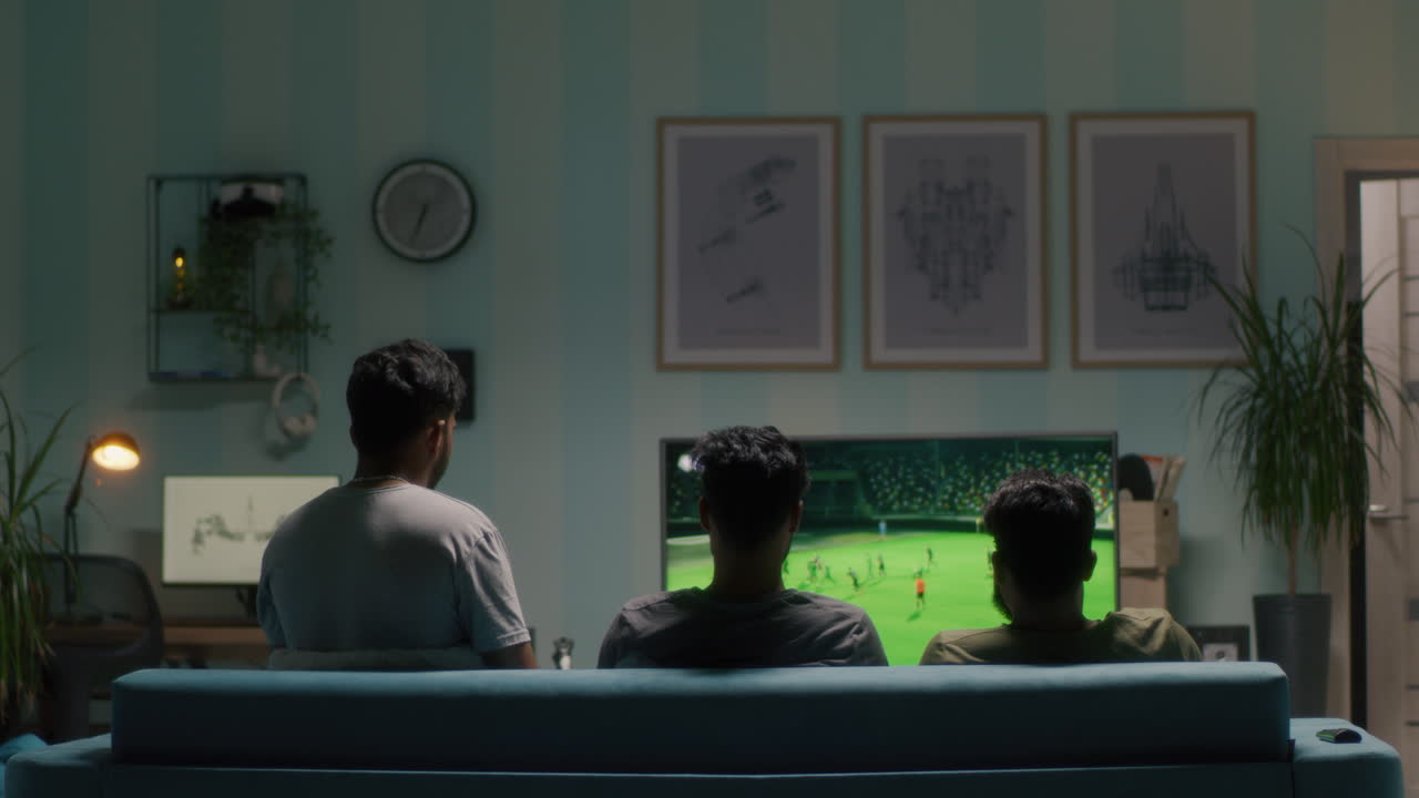 친구들이 집에서 축구 경기를 보고 있습니다.