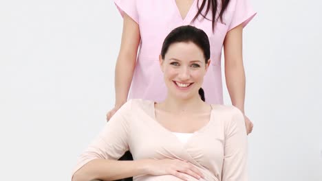 pregnant woman sitting on wheelchair and a nurse