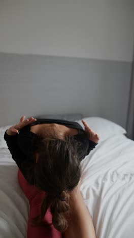 mujer practicando yoga en una cama