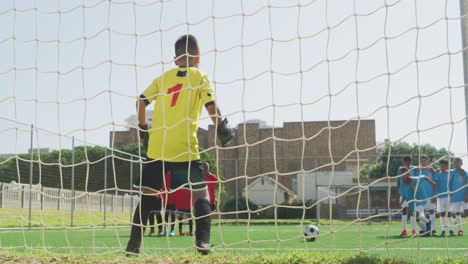 african american kid in blue scoring in a sunny day