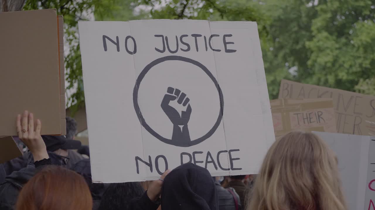 Protester holding sign against racism and for justice at a black lives matter protest in Stuttgart, Germany.