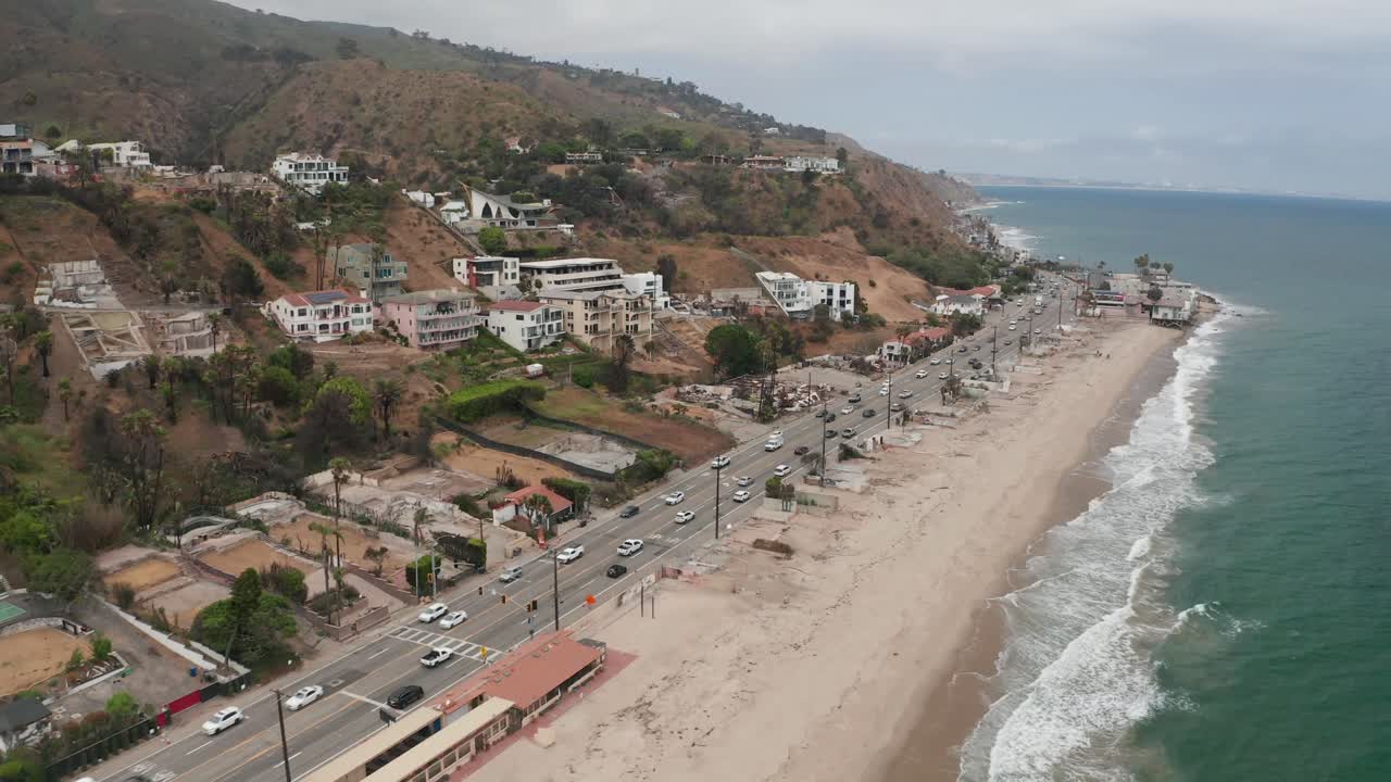 Aerial rising shot flying over the Malibu coastline at Las Flores Canyon after the Palisades Fire in Southern California. 4K