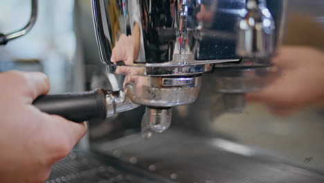 Barista hands inserting coffee device making delicious coffee closeup. Cafe shop