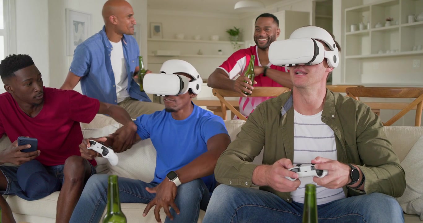 Amigos homens diversos em casa assistindo dois homens colocando óculos de VR, segurando controles para se divertir