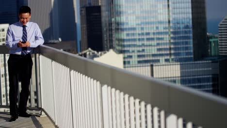 asian male business consultant using touchscreen on rooftop