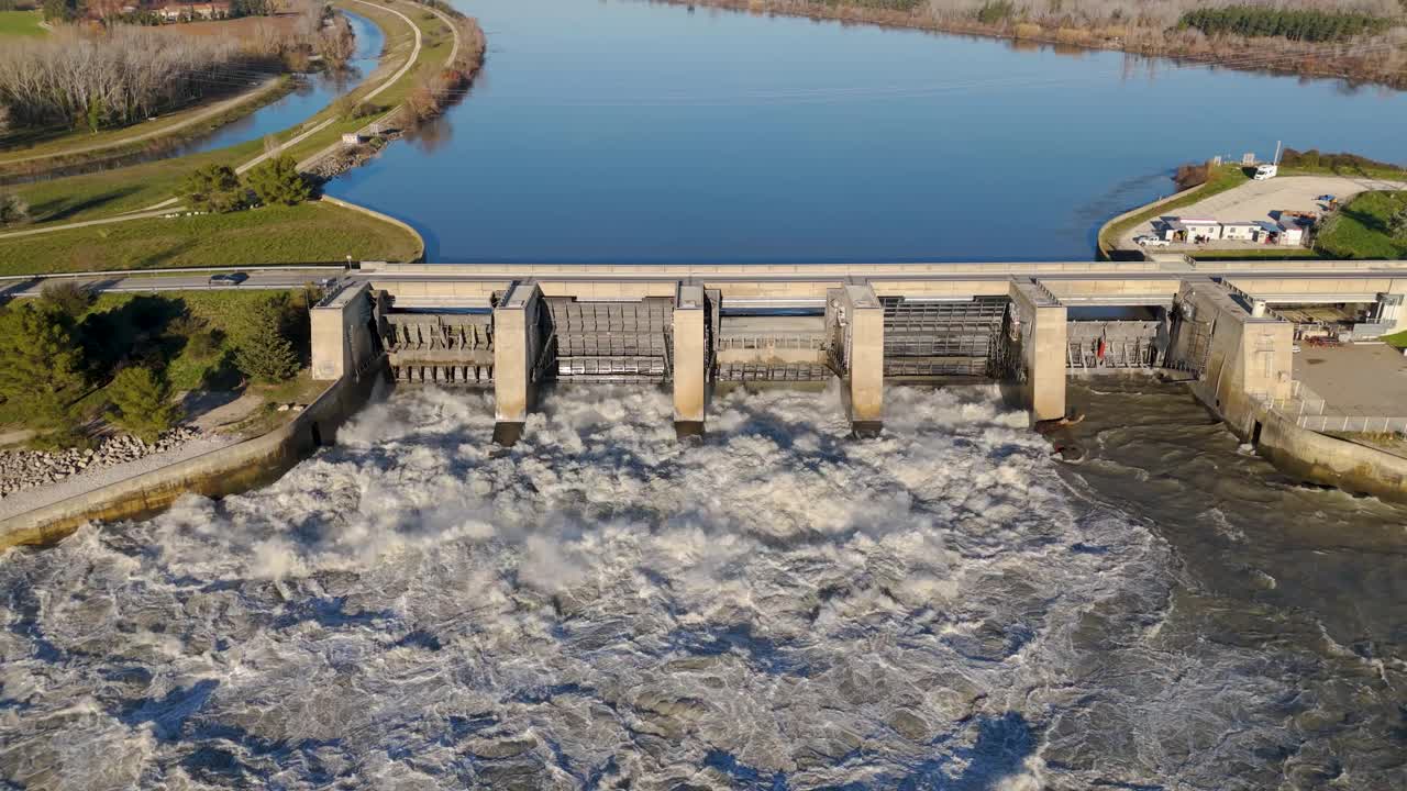 Aerial establishing shot of water flowing through the Villeneuve Dam in Avignon