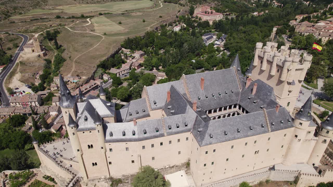 Aerial: Alc&aacute;zar de Segovia with Spain Flag flying proudly amidst Scenic landscape