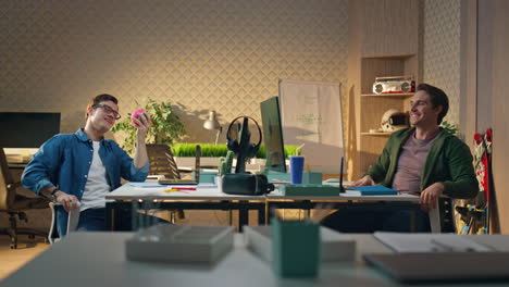 happy coworkers giving five to each other at computer table. guys enjoying break