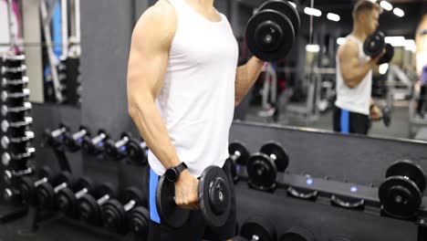 man doing dumbbell curls at the gym