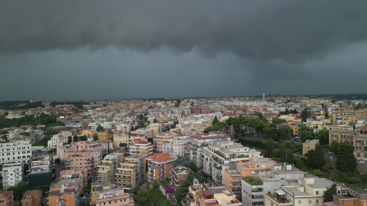 Vorwärts gerichteter Drohnenflug von dichten dunklen Regenwolken über Wohngebäuden in Rom, Italien an einem stürmischen Tag