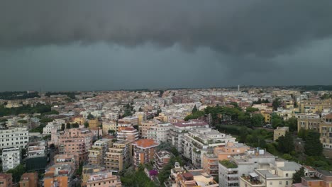 aerial drone forward moving shot of thick dark rain clouds over residential buildings in rome, italy on a stormy day