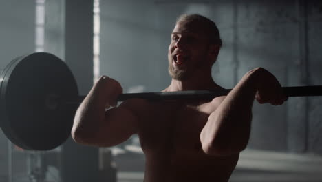 man lifting weights in gym. strong guy shoulder press exercise during training