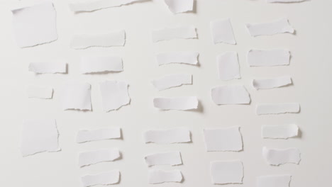 video de un primer plano de varias piezas de papel rasgadas sobre un fondo blanco