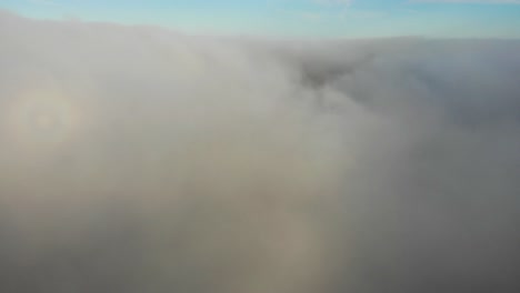 Toma-Aérea-Que-Sube-Y-Atraviesa-Las-Nubes-Para-Revelar-Un-Cielo-Azul