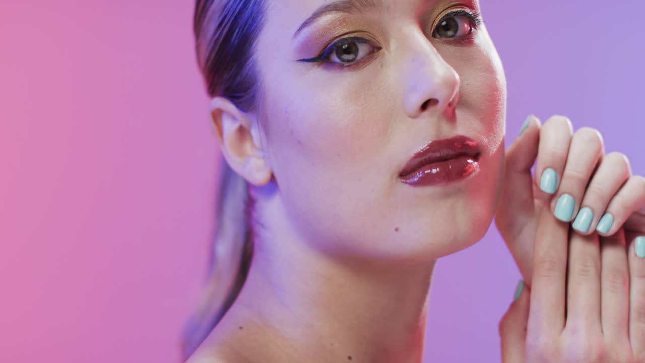 mujer caucásica con cabello rubio y maquillaje tocando su cara, copia espacio, cámara lenta