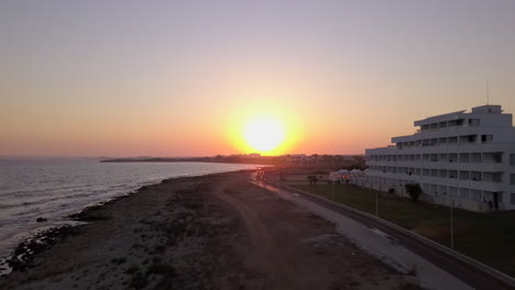 Toma-Aérea-De-Una-Puesta-De-Sol-Sin-Nubes-De-La-Costa-Del-Mar-En-Un-Centro-Vacacional