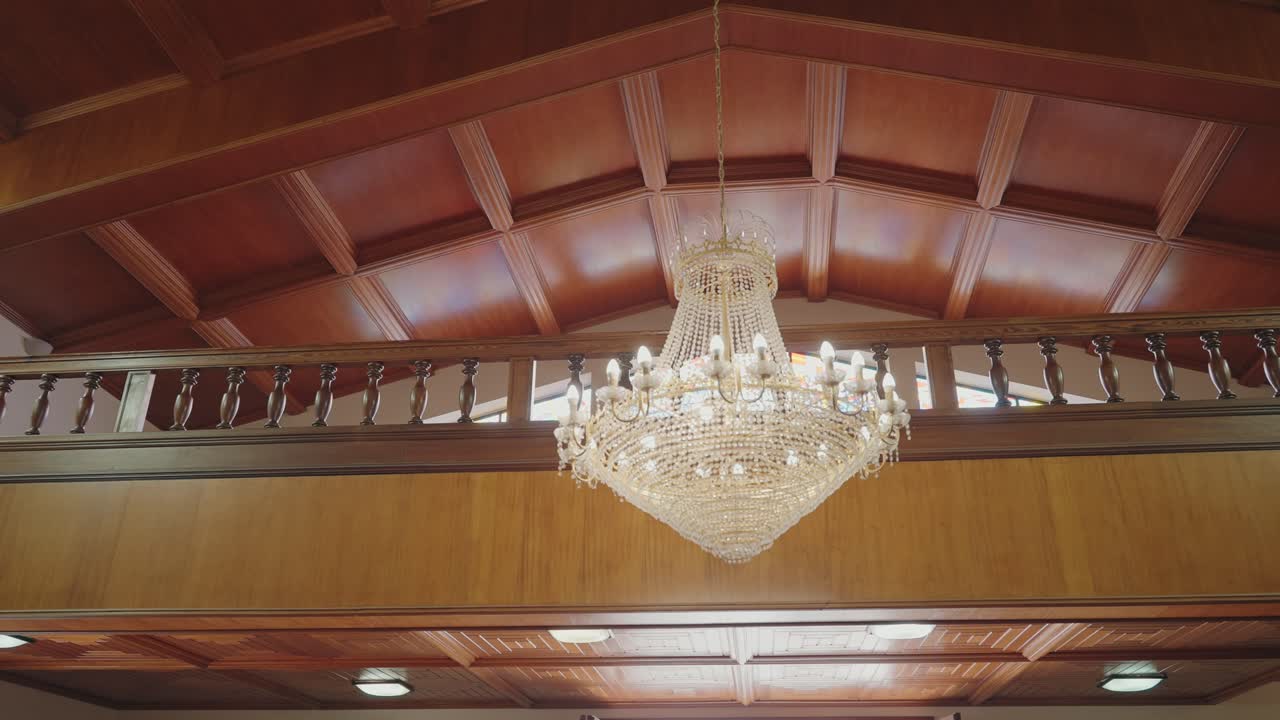 Grande lampadario di cristallo sospeso sotto un soffitto in legno all'interno