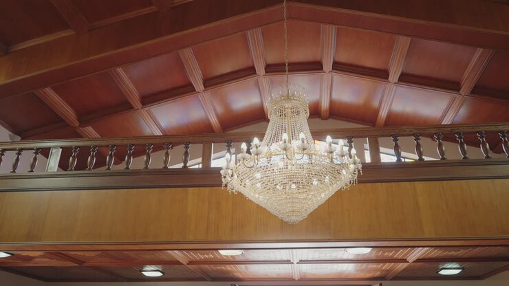 Grande lampadario di cristallo sospeso sotto un soffitto in legno all'interno