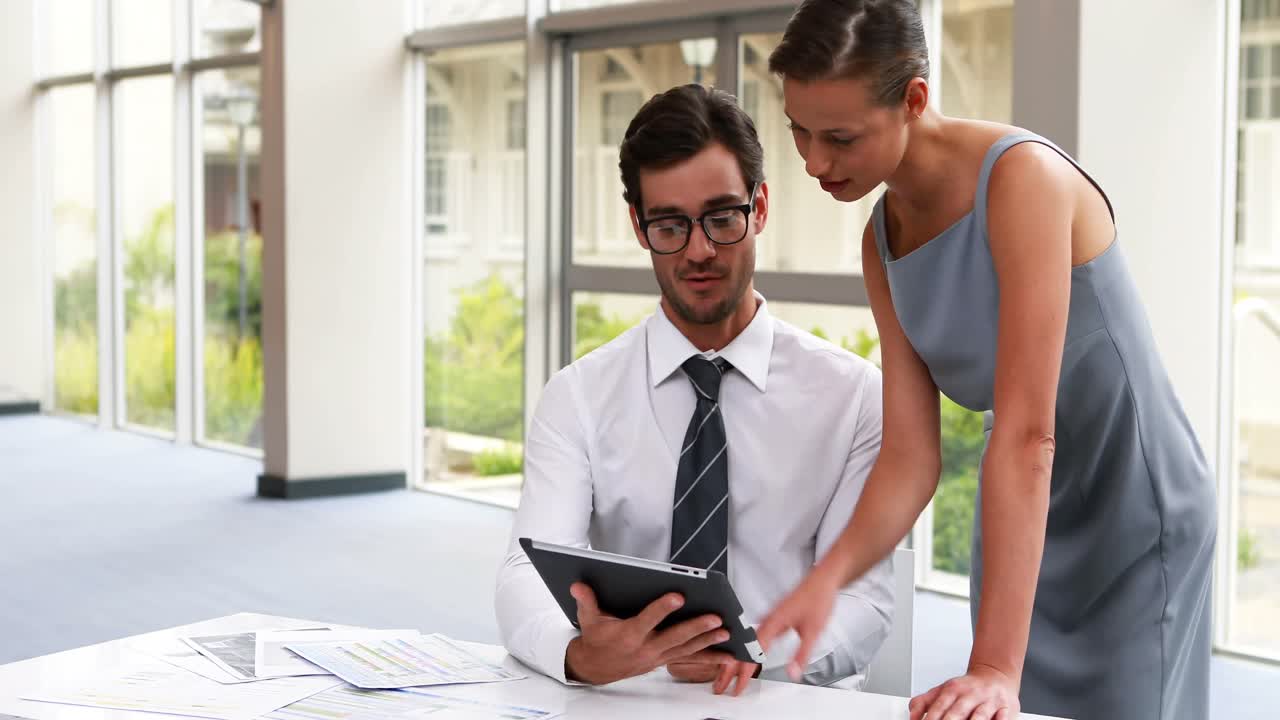 ejecutivos de negocios discutiendo sobre una tableta digital 4k