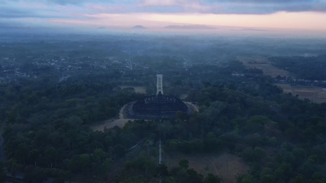 vista aérea del templo de borobudur en una mañana brumosa cuando todavía está oscuro con un cielo naranja antes del amanecer