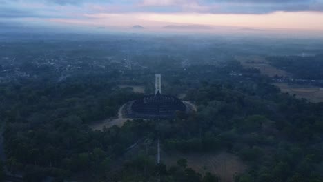 vista aérea del templo de borobudur en una mañana brumosa cuando todavía está oscuro con un cielo naranja antes del amanecer