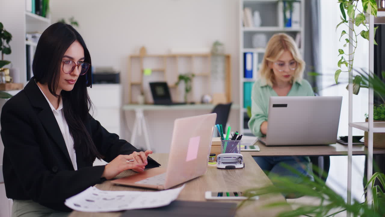Team af kvindelige kontormedarbejdere arbejder på laptops