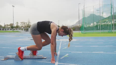 side view of caucasian athlete preparing for race in stadium