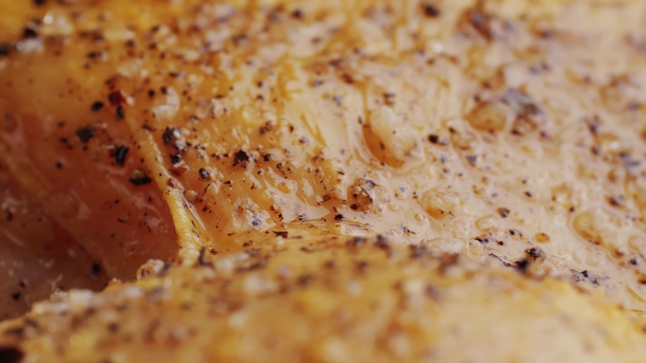 Primo piano di carne di pollo condita con pepe nero