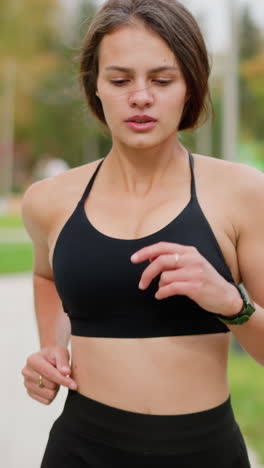 close-up view of athletic woman jogging outdoors, breathing deeply and focusing on her exercise, ideal for content about fitness, cardio, healthy living, and outdoor activities