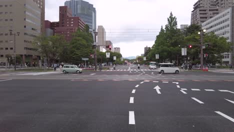 Person-Crossing-Hiroshima-Street-Near-Driving-Cars,-Japan