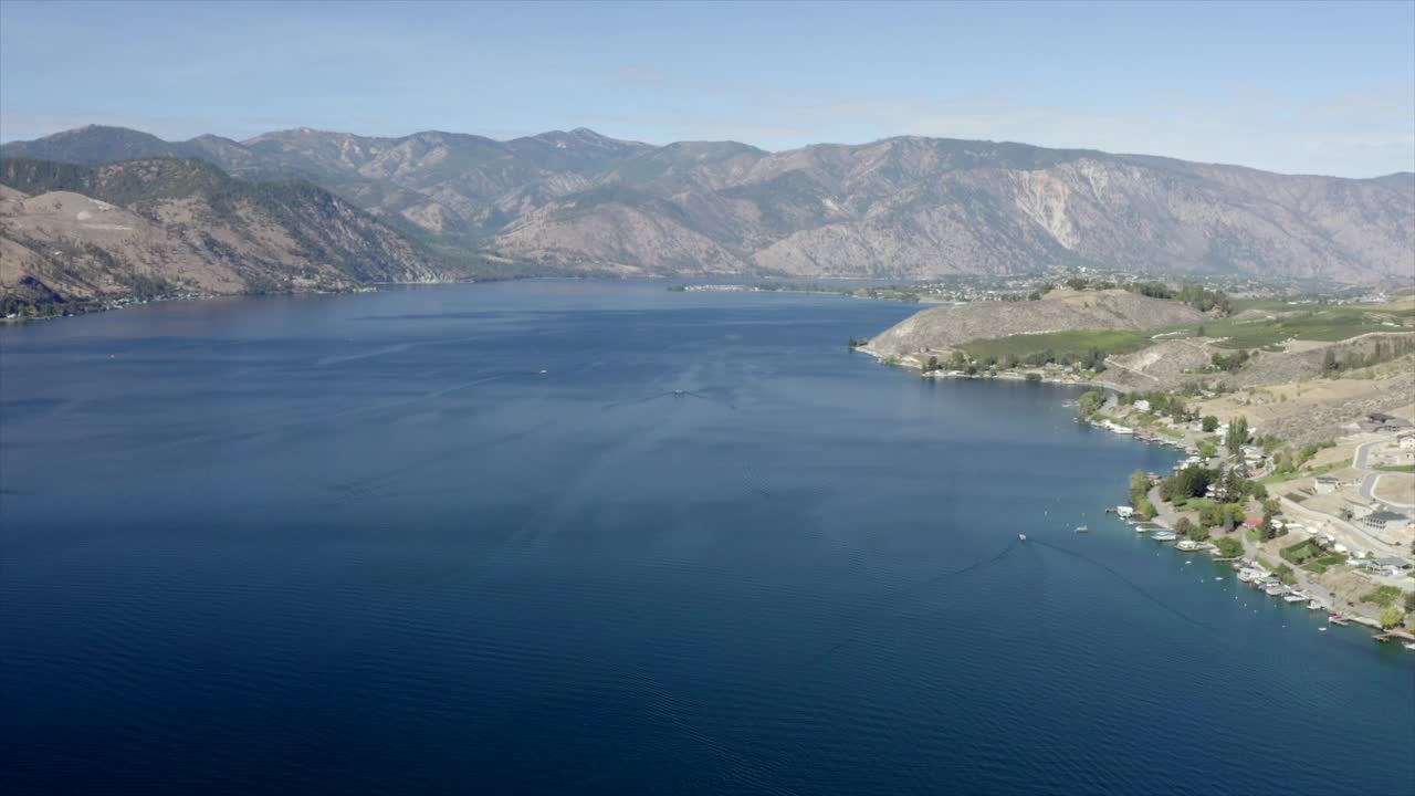 호수와 산을 향해 집 위로 날아가는 드론