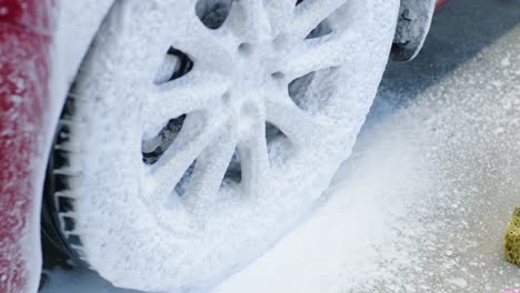 red car wash with flowing water and foam.