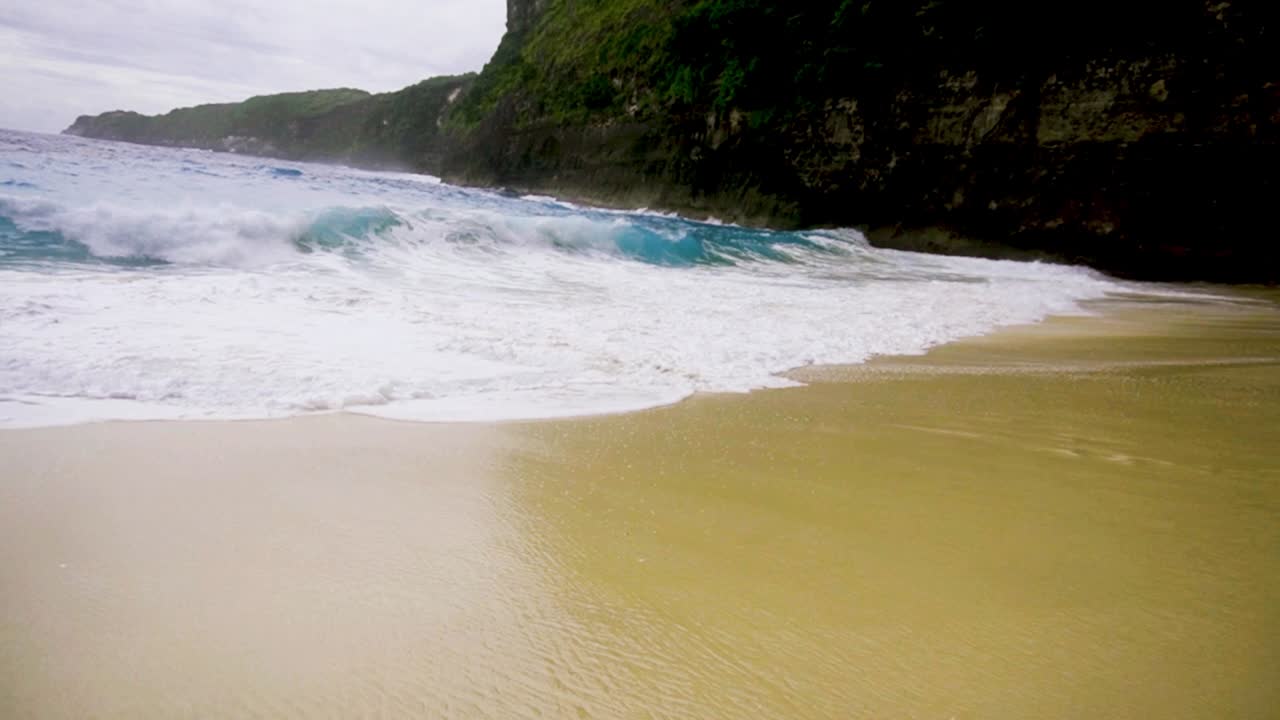 Bellissima costa sabbiosa della spiaggia di Kelingking mentre le onde si infrangono