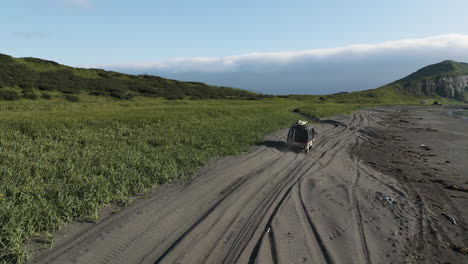 van driving along sandy beach heading for destination unknown