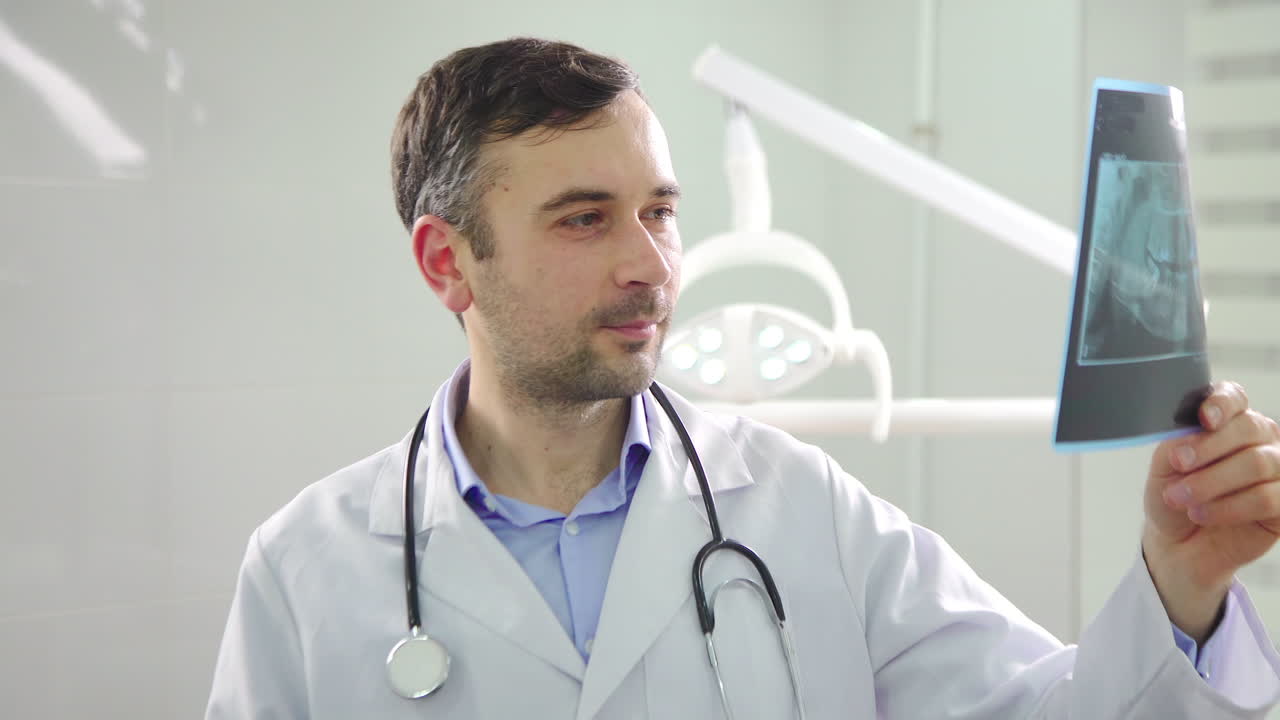 Diş kliniğinde kameraya bakan doktor