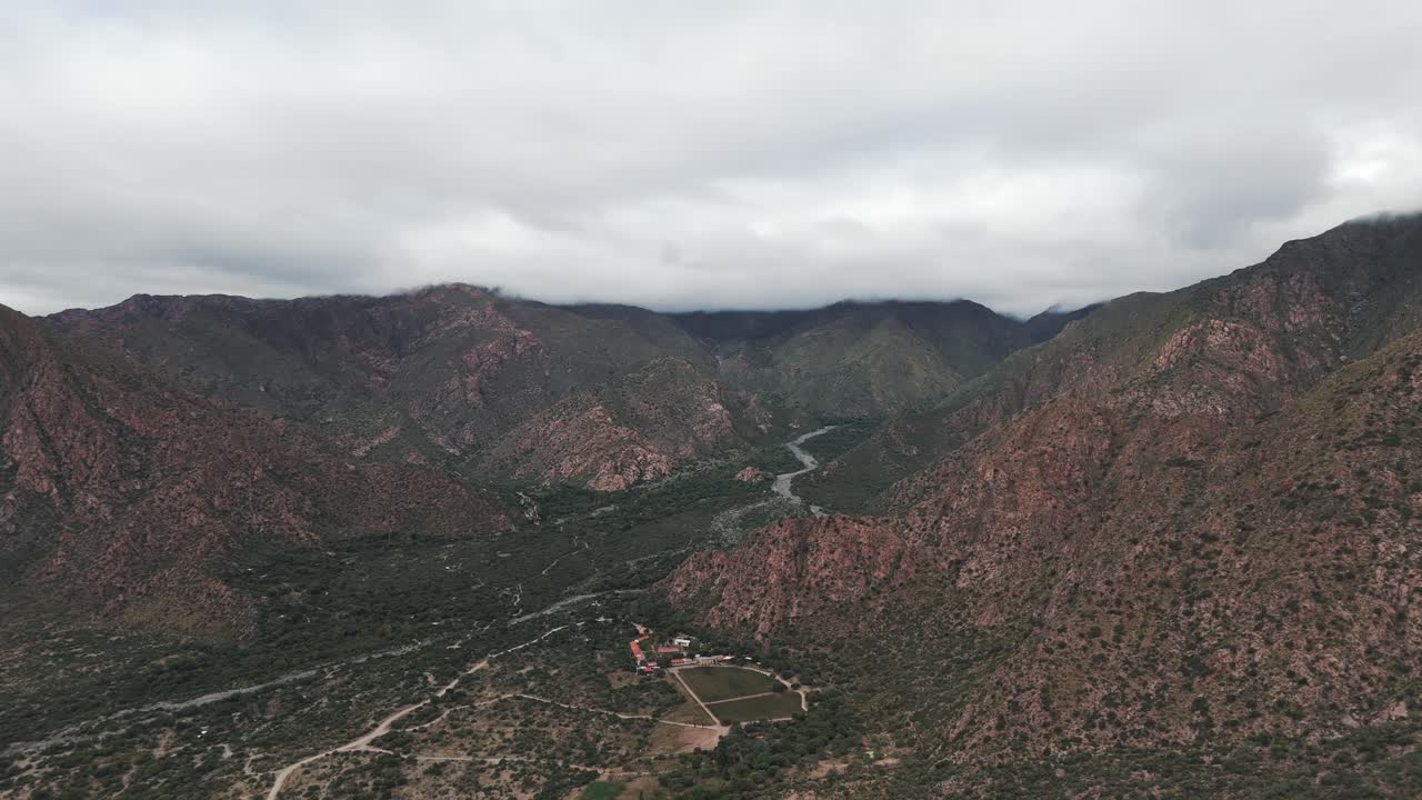 Aerial view of the mountains, valley with a river in a cloudy day in Cafayate, Salta Argentina.