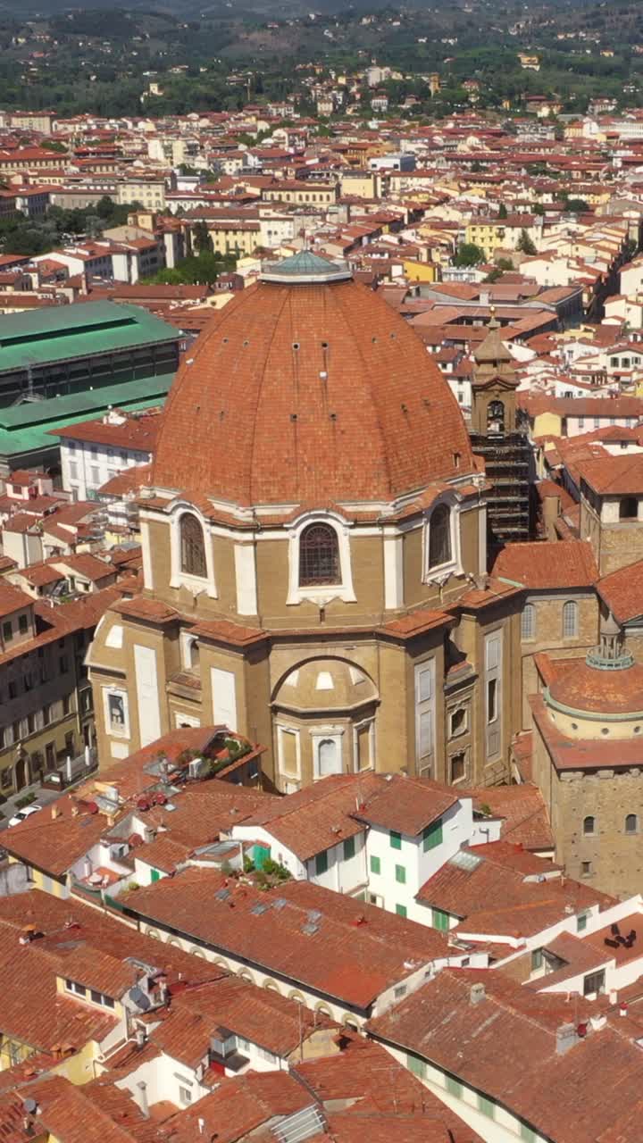 Panoramica aerea verticale verso l'alto che rivela una splendida Basilica e la città in una giornata di sole a Firenze, in Italia